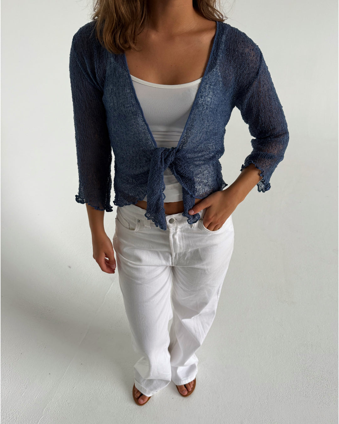 Modelfoto af pige som bærer en Arabella bluse i blå, samt et par hvide jeans. Alt fra By Sofie Sønderby