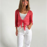 Modelfoto af pige som bærer en Arabella bluse i coral, samt et par hvide jeans. Alt fra By Sofie Sønderby