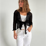 Modelfoto af pige som bærer en Arabella bluse i sort, samt et par hvide jeans. Alt fra By Sofie Sønderby