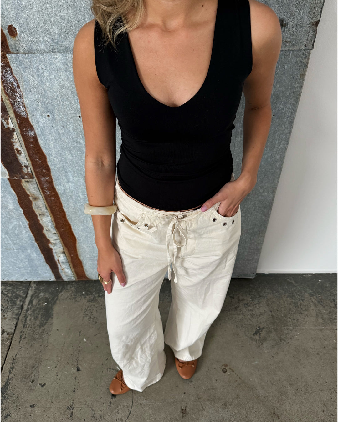 Modelfoto af pige der bærer Blakely top i sort, samt beige bukser. Alt fra BySofieSønderby