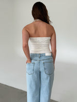 Modelfoto af pige med CHRISTINE top, hvid og NANNA jeans, lyseblå - begge fra fra BySofieSønderby