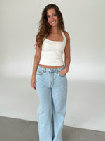 Modelfoto af pige med CHRISTINE top, hvid og NANNA jeans, lyseblå - begge fra fra BySofieSønderby
