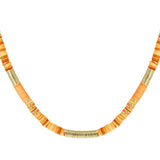 Halskæde med flade orange og gyldne perler arrangeret i mønster; perlerne sidder tæt sammen og danner et buet mønster mod en hvid baggrund.