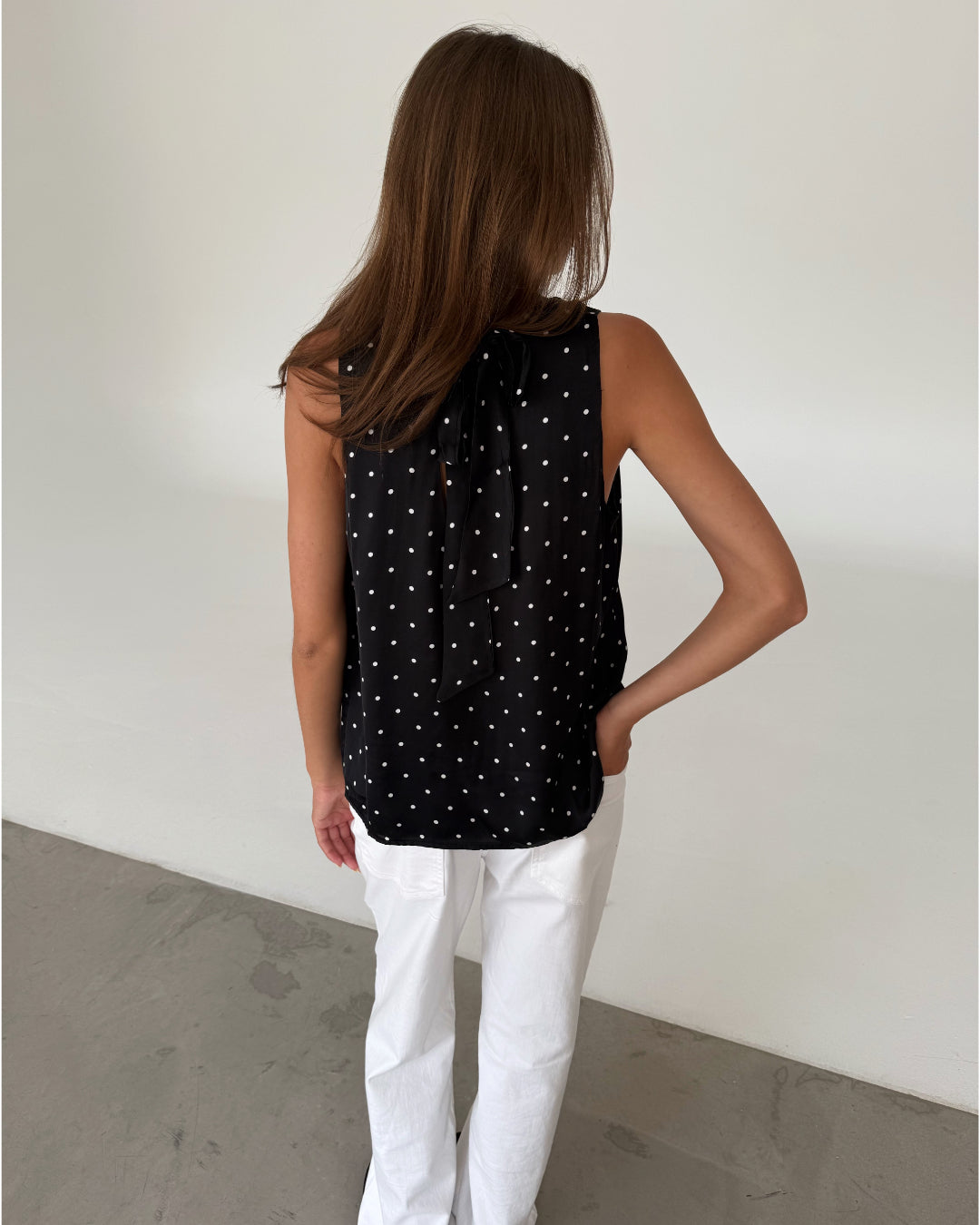 Modelfoto af pige med FANNY top, sort og NANNA bukser, hvid - begge fra fra BySofieSønderby