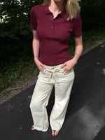 Modelfoto af pige i en bordeaux Hadley polo og cremefarvede Adrianna jeans. Alt er fra BySofieSønderby