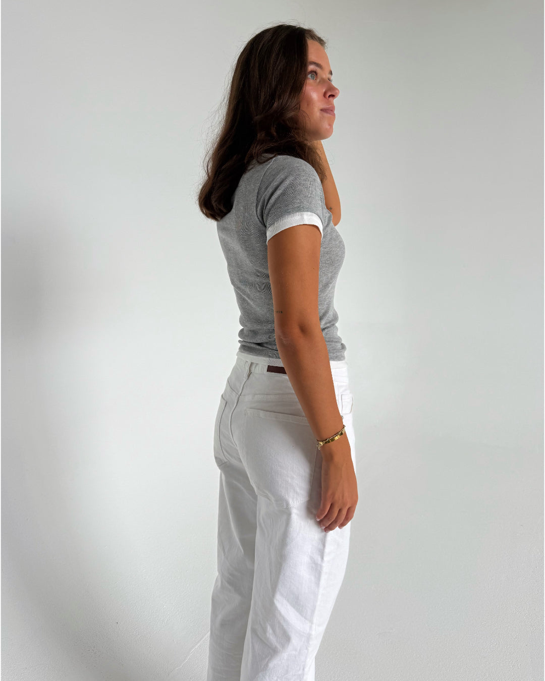 Modelfoto af pige som bærer en Henna t-shirt i grå, samt hvide Nanna jeans. Alt fra By Sofie Sønderby