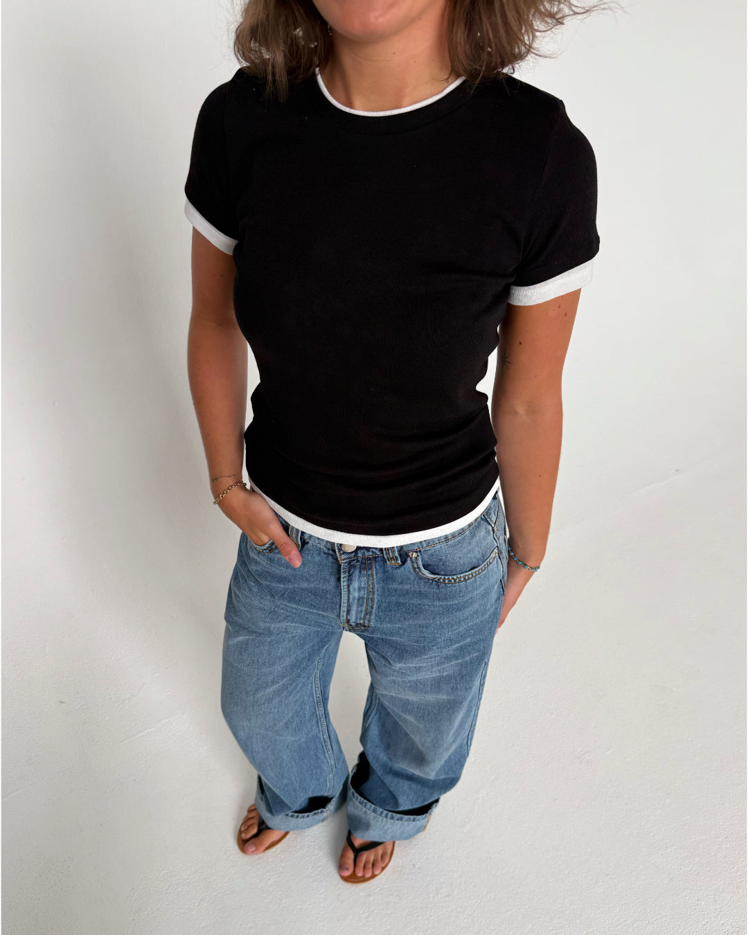 Modelfoto af pige som bærer en Henna t-shirt i sort, samt blå Nanna jeans. Alt fra By Sofie Sønderby