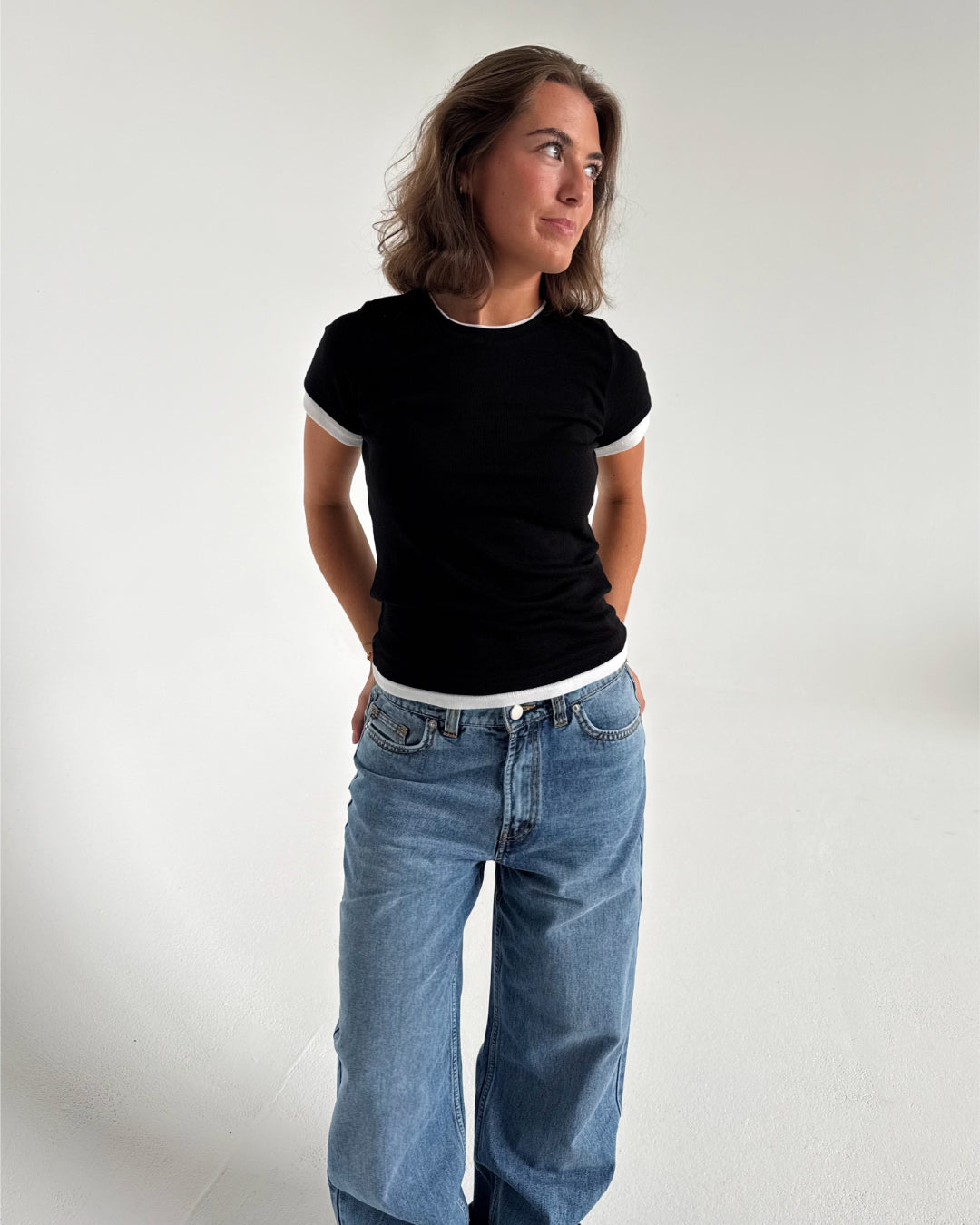 Modelfoto af pige som bærer en Henna t-shirt i sort, samt blå Nanna jeans. Alt fra By Sofie Sønderby
