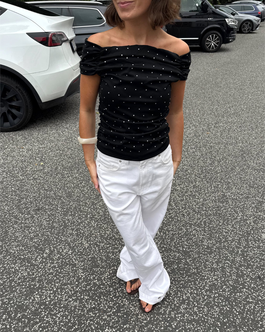 Modelfoto af pige med REYA top, sort og NANNA jeans, hvid - begge fra BySofieSønderby