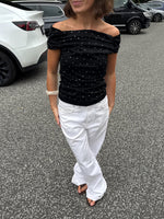 Modelfoto af pige med REYA top, sort og NANNA jeans, hvid - begge fra BySofieSønderby