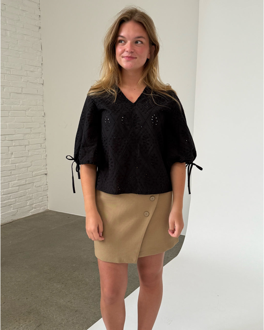 Modelfoto af pige iklædt JOELLA bluse, sort og NOAH nederdel, sand - begge fra BySofieSønderby