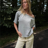 Modelfoto af pige i grå Karsyn wideneck t-shirt og cremefarvede Adrianna jeans. Alt er fra BySofieSønderby