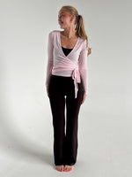 Modelfoto af pige i lyserød Luna wrap bluse og brune Sania bukser. Fra BySofieSønderby