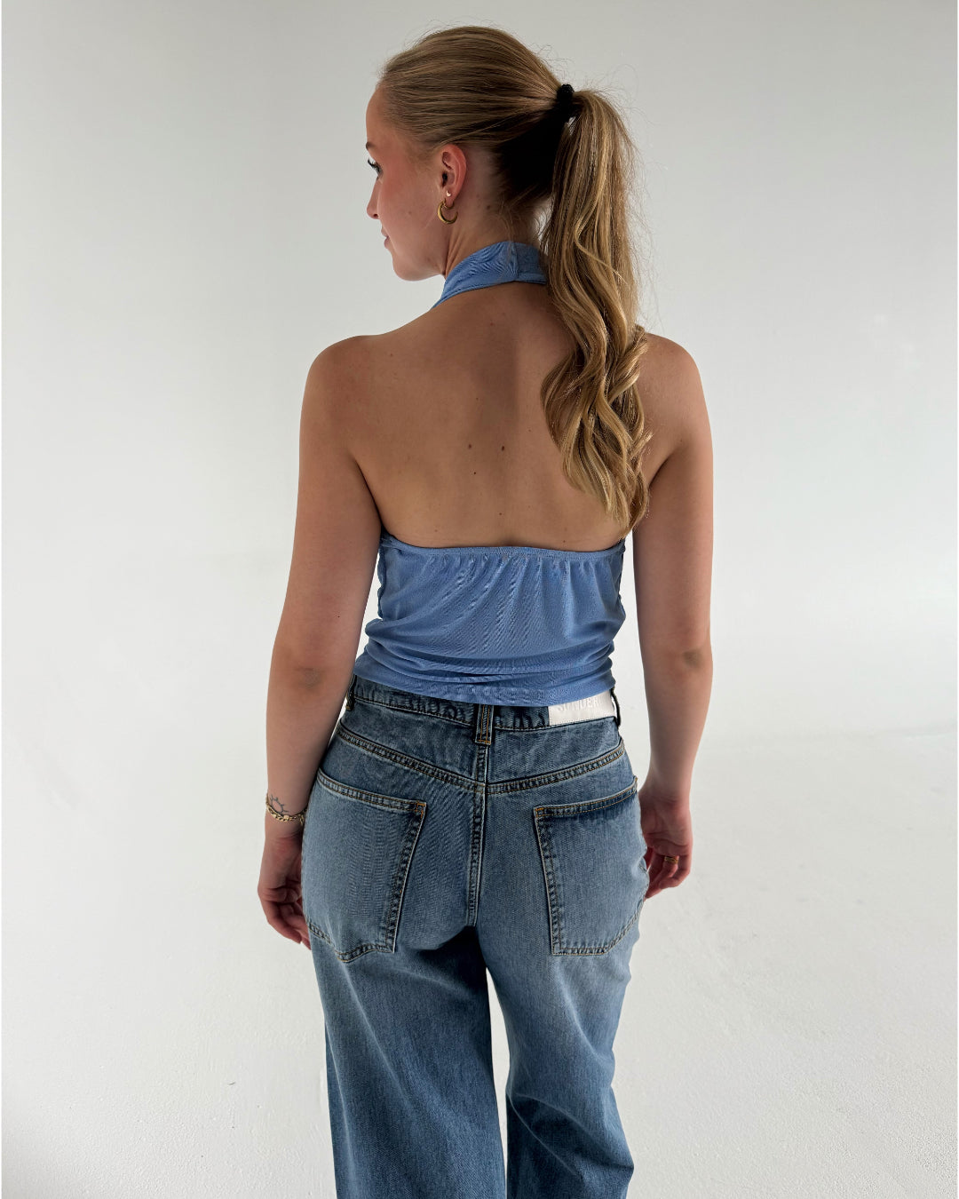 Modelfoto af pige der bærer Mavis top i blå, samt blå Nanna Jeans. Alt fra BySofieSønderby
