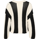 Sort-hvid stribet sweater ligger fladt, viser ryggen med lodrette striber i groft strikket design. Baggrunden er ensfarvet hvid.