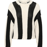 Sort-hvid strikket sweater med brede lodrette striber hænger mod en neutral baggrund. I nakken er der en mærkat med teksten "soaked".