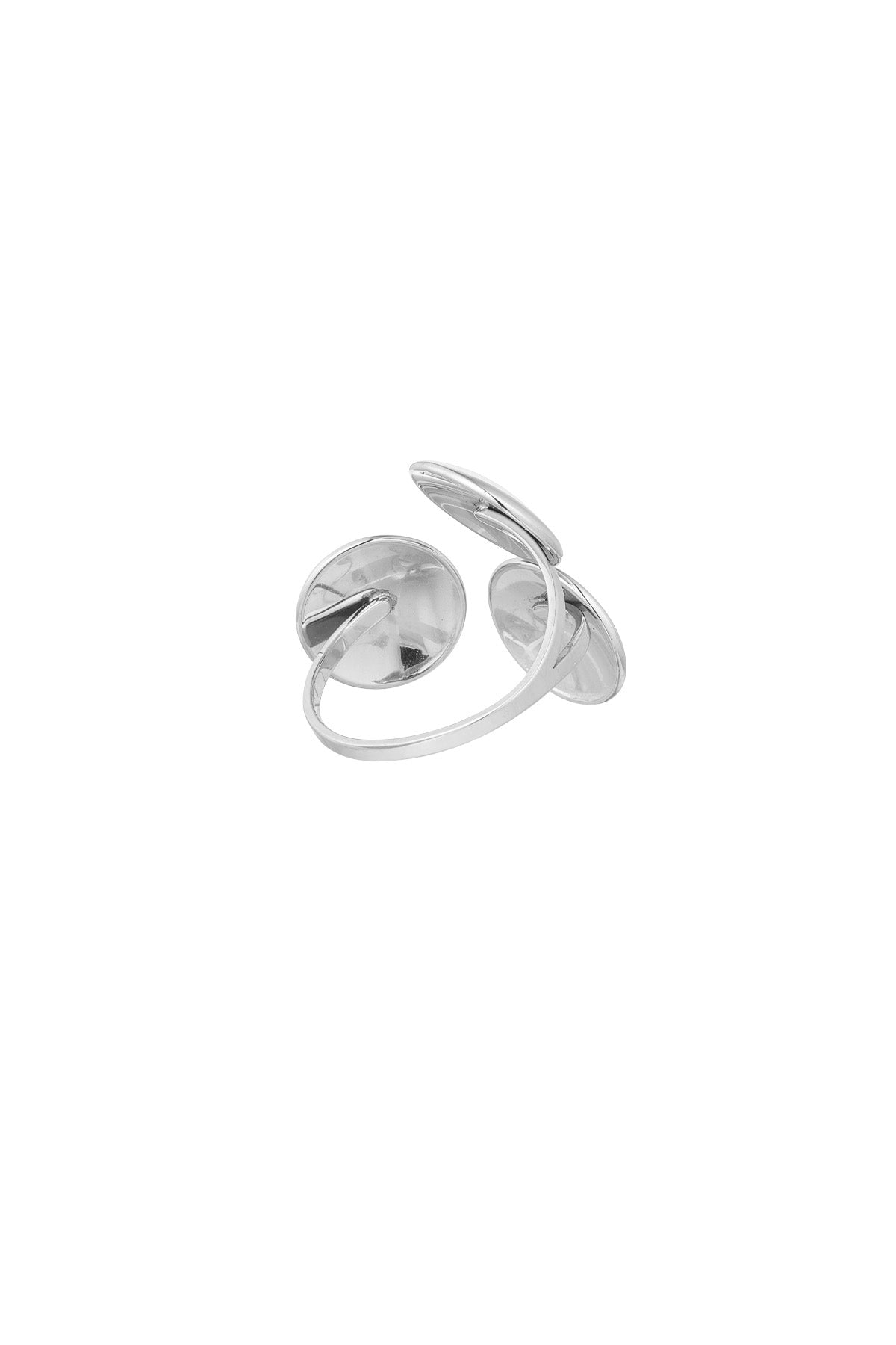 En sølvring med to overlappende, glatte skiver formet som skaller, ligger på en hvid baggrund. Ringen har en elegant og moderne æstetik.