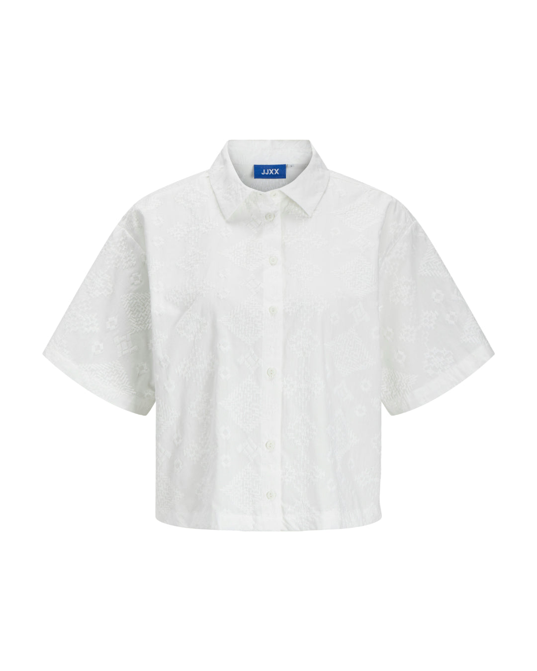 Kortærmet hvid skjorte med knapper, prydet med diskrete mønstre i stoffet. Den hænger mod en enkel, hvid baggrund. Mærkatet på indersiden har teksten "JJXX".