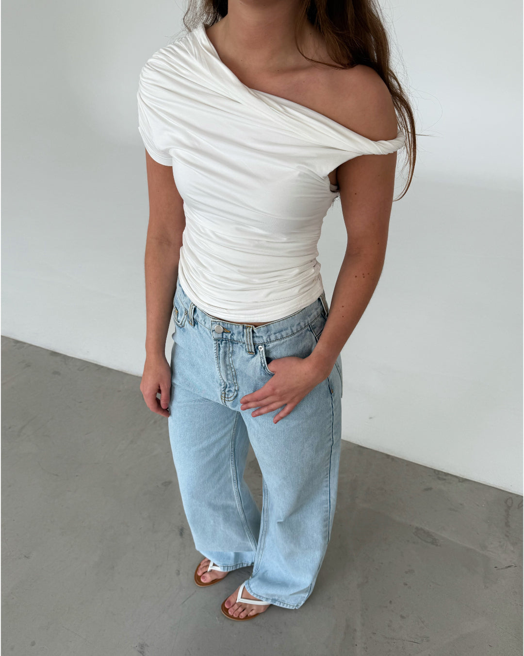 Modelfoto af pige med MILENA off shoulder top, hvid og NANNA jeans, lyseblå - begge fra BySofieSønderby
