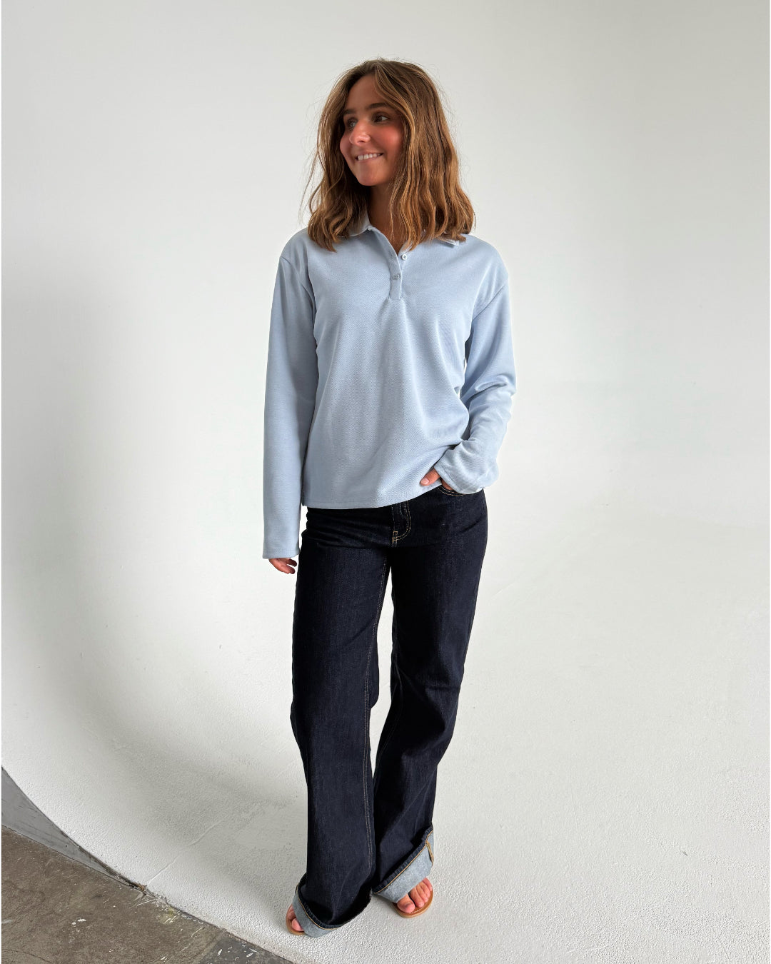 Modelfoto af pige der bærer en lyseblå Millie bluse, samt mørkeblå jeans. Alt fra BySofieSønderby
