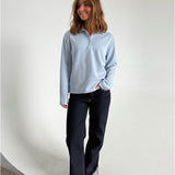 Modelfoto af pige der bærer en lyseblå Millie bluse, samt mørkeblå jeans. Alt fra BySofieSønderby