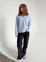 Modelfoto af pige der bærer en lyseblå Millie bluse, samt mørkeblå jeans. Alt fra BySofieSønderby