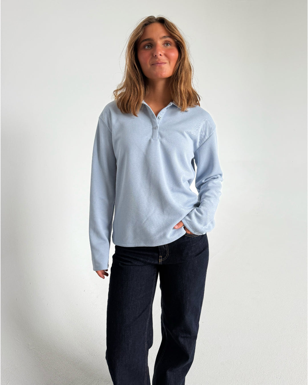 Modelfoto af pige der bærer en lyseblå Millie bluse, samt mørkeblå jeans. Alt fra BySofieSønderby