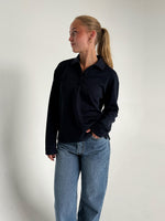Modelfoto af pige der bærer en navy farvet Millie bluse, samt hvide Nanna jeans. Alt fra BySofieSønderby