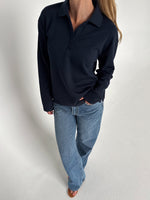 Modelfoto af pige der bærer en navy farvet Millie bluse, samt hvide Nanna jeans. Alt fra BySofieSønderby