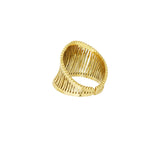En guldarmbånd med et snoet, åbent design, ligger på en hvid baggrund. Armbåndet har en bred struktur med parallelle stænger, der giver en let og elegant udstråling.