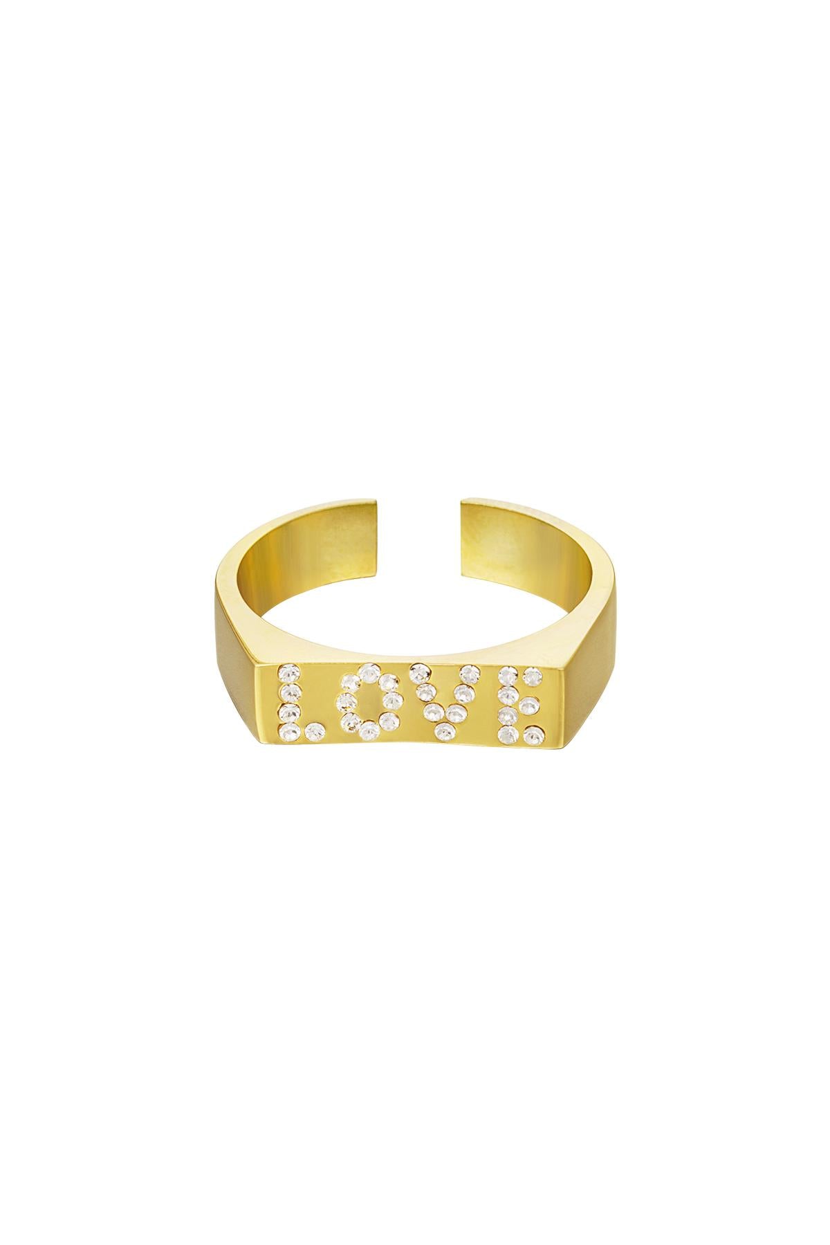 En guldring med indgraverede diamanter staver ordet "LOVE" på forsiden, placeret mod en hvid baggrund.