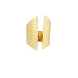 Guldring med tekstureret, bølget overflade, står oprejst mod en hvid baggrund. Ringskinnen er åbnet i midten og fremstår elegant med et unikt design.