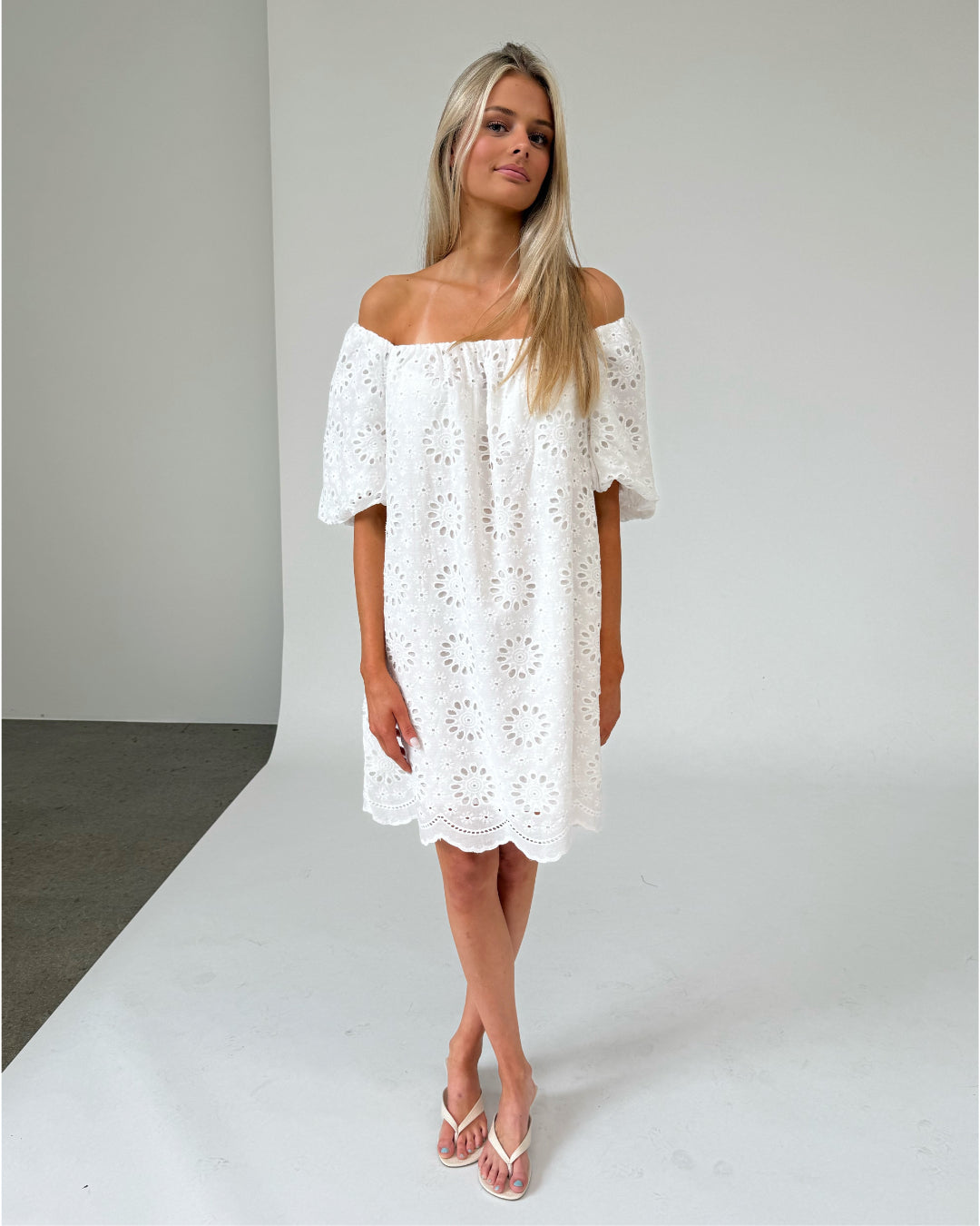 Modelfoto af pige som bærer hvid PALMA off-shoulder kjole med mønster. Alt er fra BySofieSønderby