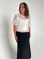 Modelfoto af pige som bærer en Rose bluse i hvid, samt en Breeze nederdel i navy. Alt fra By Sofie Sønderby