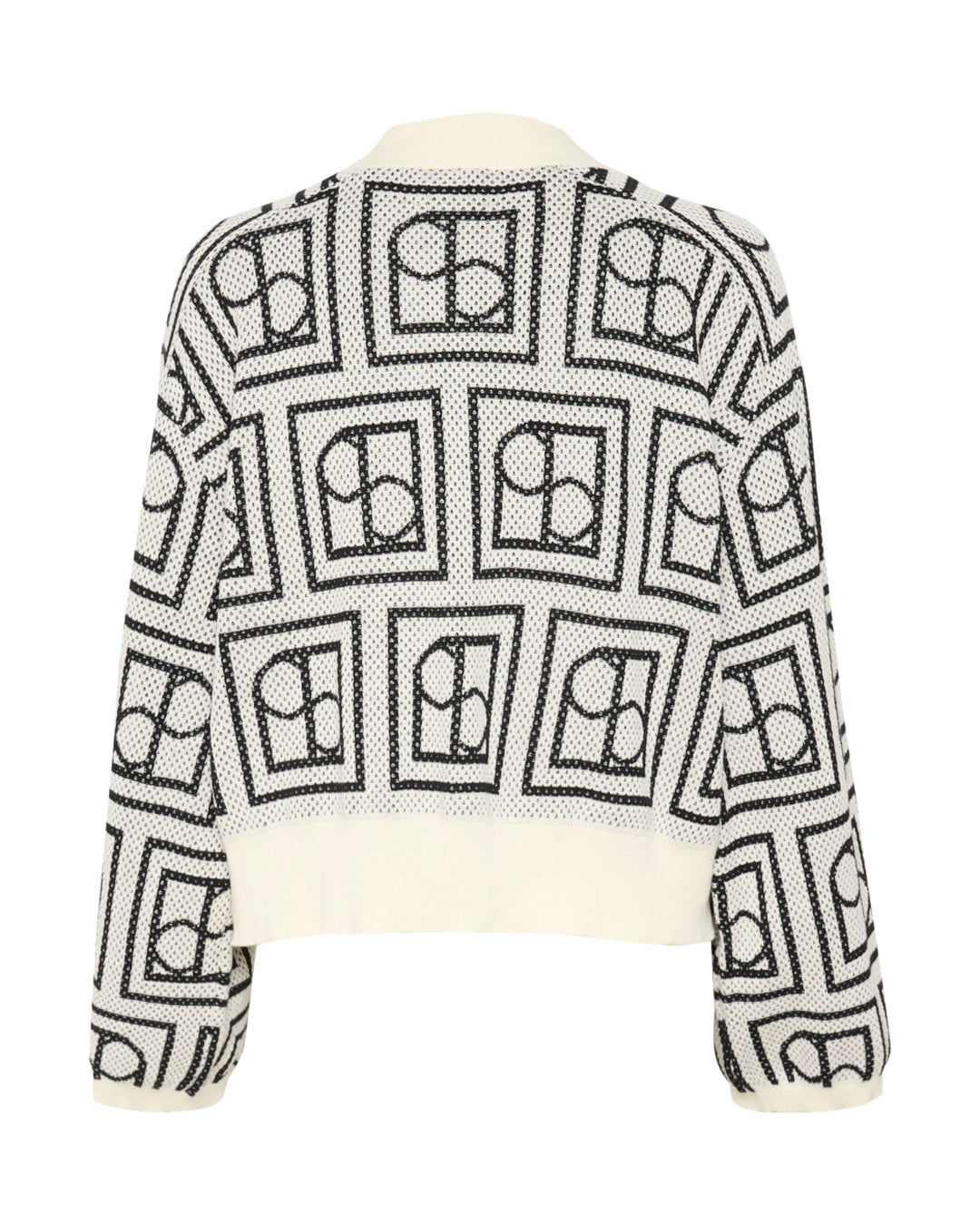 En hvid sweater med sort, geometrisk mønster bestående af kvadrater indeholdende cirkler og halve cirkler, ses mod en hvid baggrund.