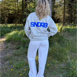 Modelfoto af pige, som bærer SNDRB sweatshirt, grå og NANNA jeans, hvid - alt fra BySofieSønderby