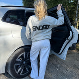 Modelfoto af pige, som bærer SNDRB sweatshirt, grå og NANNA jeans, hvid - alt fra BySofieSønderby
