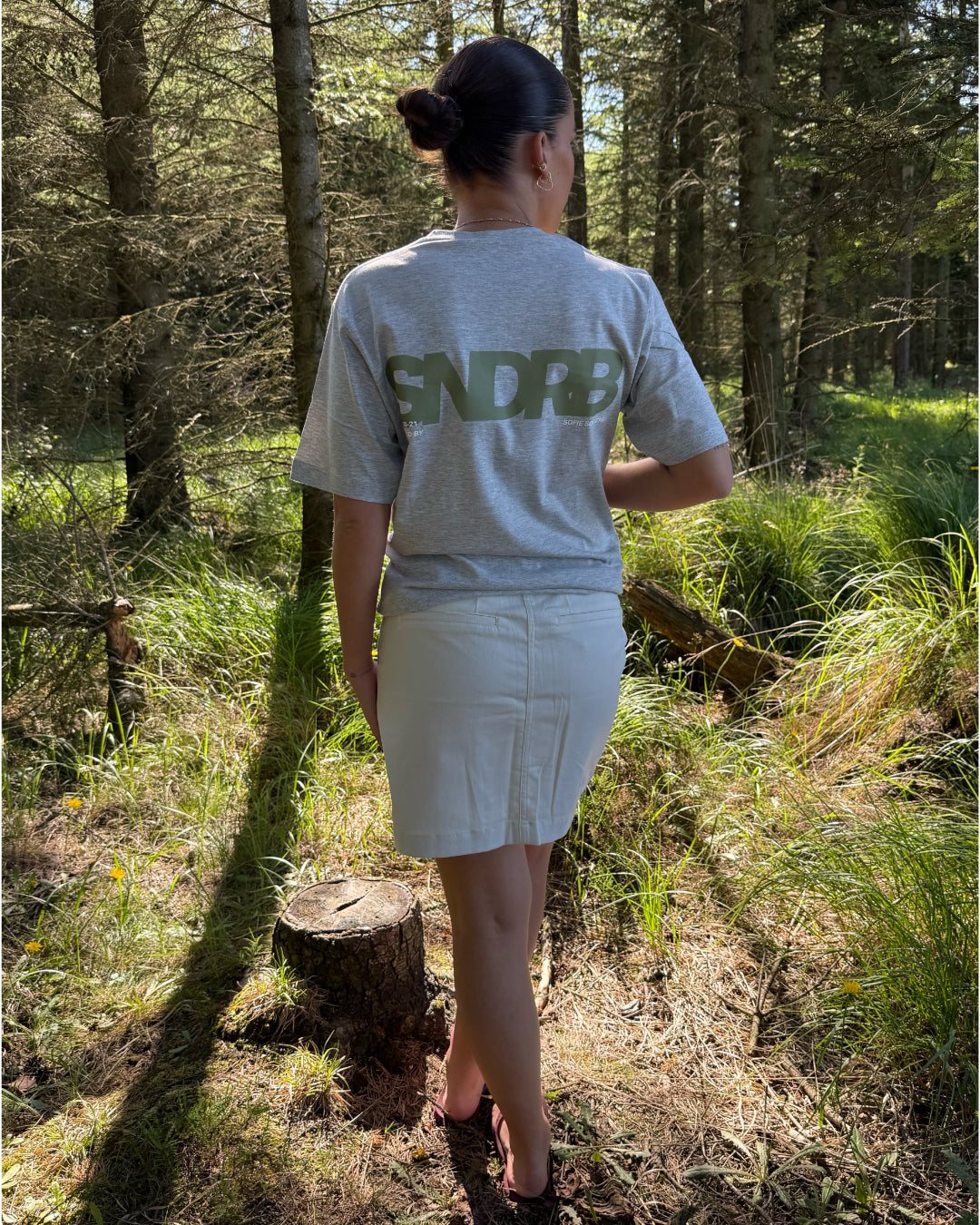 Modelfoto af pige, som bærer SNDRB t-shirt, grå og hvid nederdel - alt fra BySofieSønderby