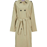 Beige trenchcoat hænger, med bælte bundet i taljen, sorte knapper og skulderstropper, mod en hvid baggrund.