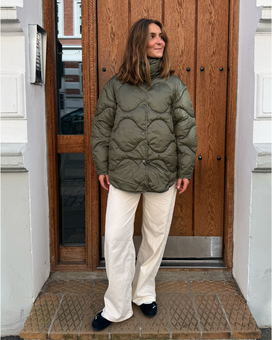 Modelfoto af pige i armyfarvet Stella jakke og beigefarvede Arianna jeans. Alt er fra BySofieSønderby