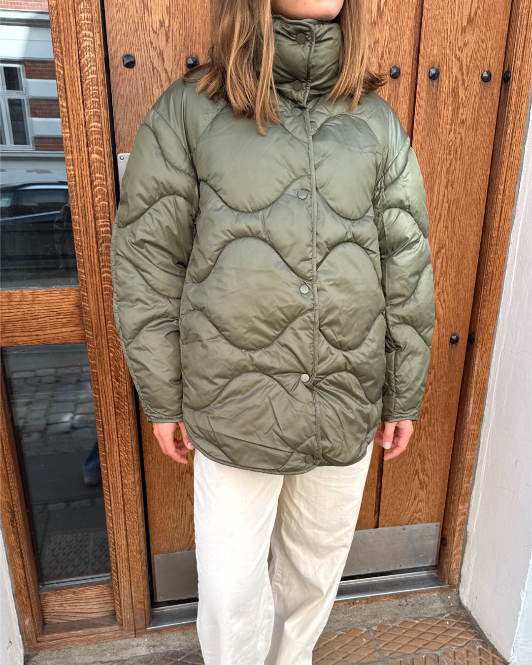 Modelfoto af pige i armyfarvet Stella jakke og beigefarvede Arianna jeans. Alt er fra BySofieSønderby