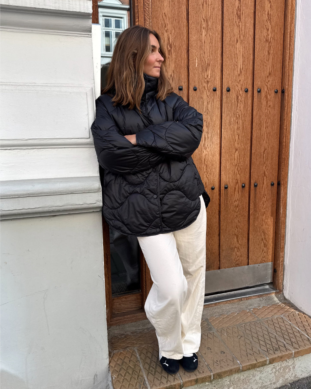 Modelfoto af pige i sort Stella jakke og beigefarvede Arianna jeans. Alt er fra BySofieSønderby