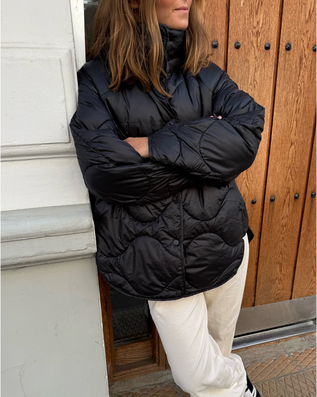 Modelfoto af pige i sort Stella jakke og beigefarvede Arianna jeans. Alt er fra BySofieSønderby