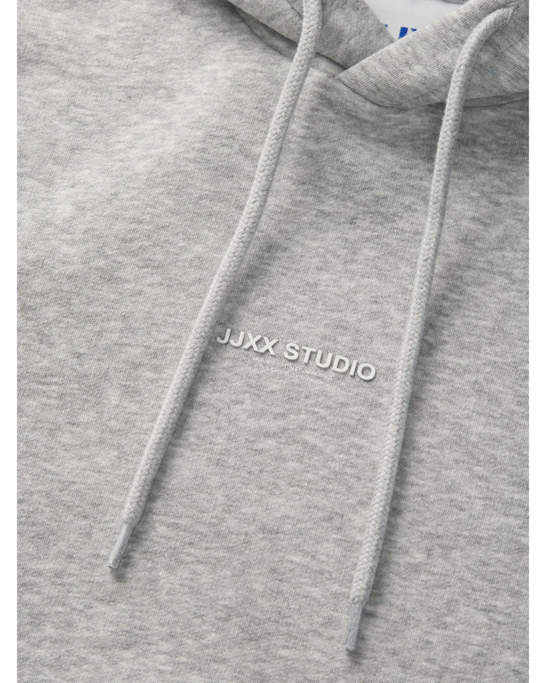 Detaljefoto af fronten på en Studio Vesterbro hoddie i lysgrå, hvor man ser skriften JJXX STUDIO. Fra BySofieSønderby
