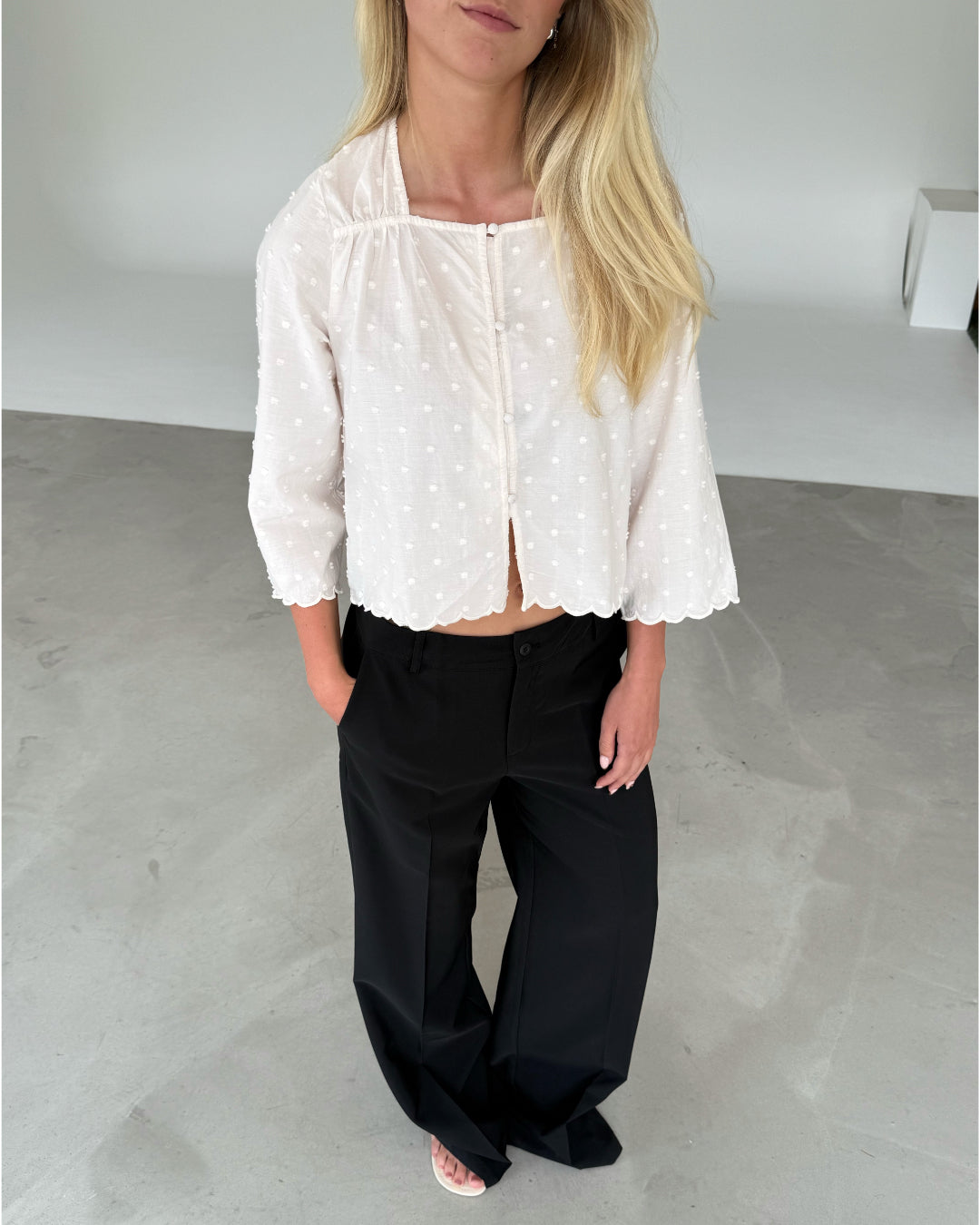 Modelfoto af pige med SUNELA bluse, hvid og ELLIS bukser, sort - begge fra BySofieSønderby