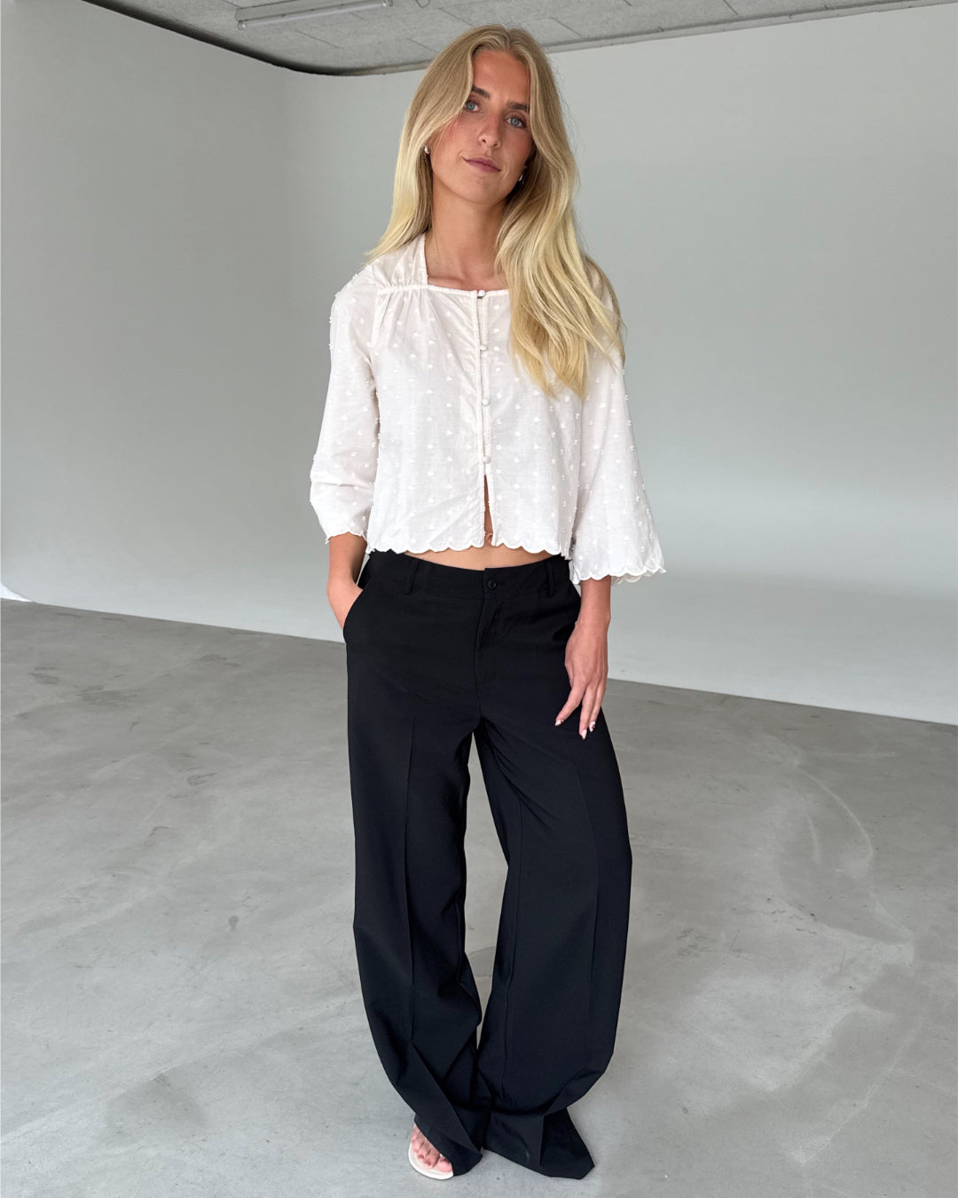 Modelfoto af pige med SUNELA bluse, hvid og ELLIS bukser, sort - begge fra BySofieSønderby