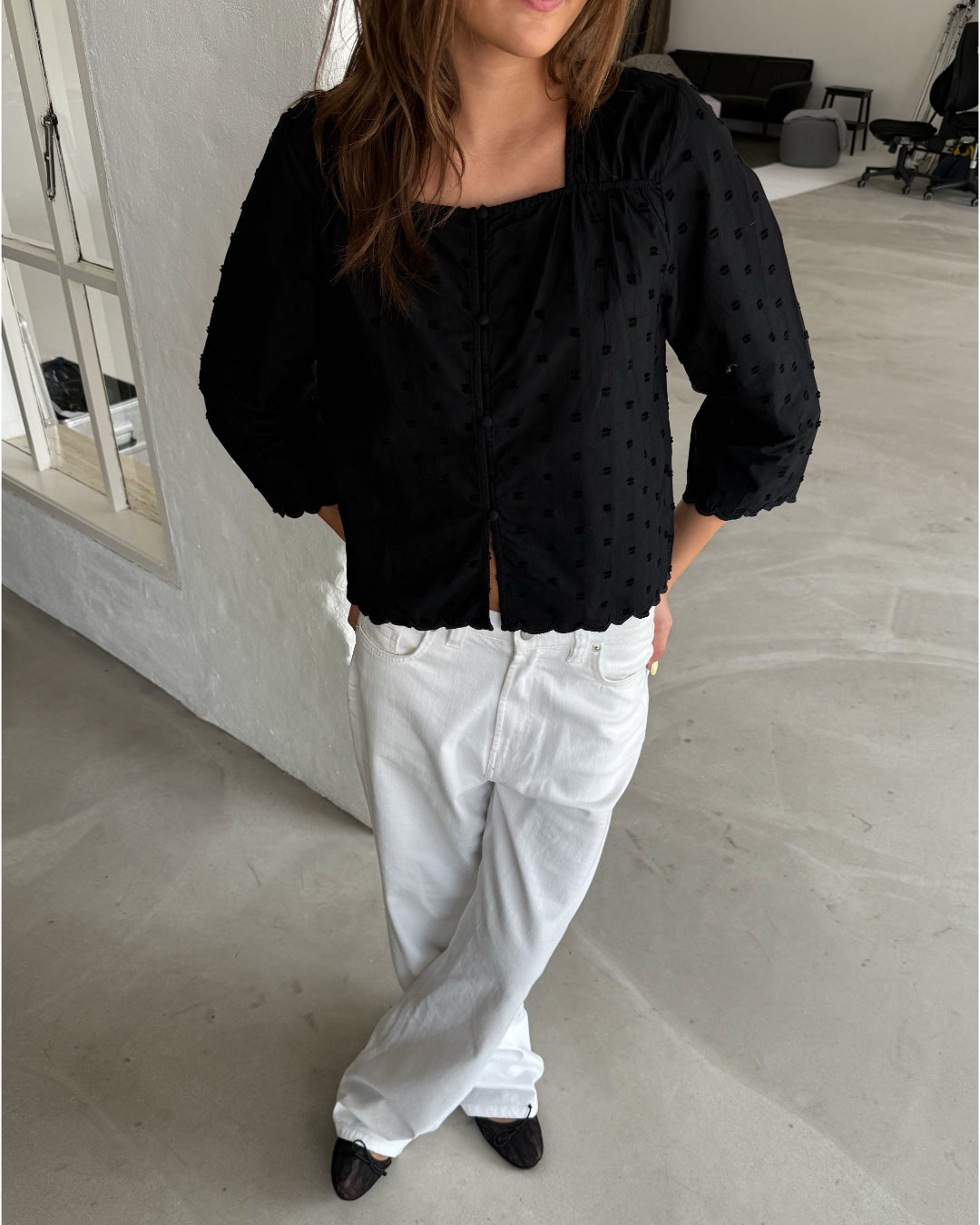 Modelfoto af pige med SUNELA bluse, sort og NANNA jeans, hvid - begge fra BySofieSønderby