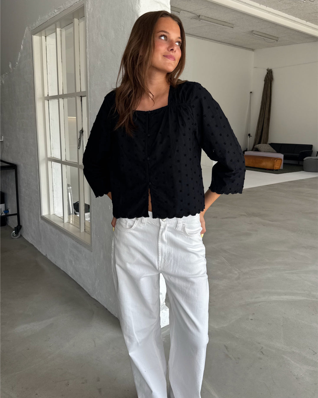 Modelfoto af pige med SUNELA bluse, sort og NANNA jeans, hvid - begge fra BySofieSønderby