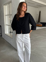 Modelfoto af pige med SUNELA bluse, sort og NANNA jeans, hvid - begge fra BySofieSønderby