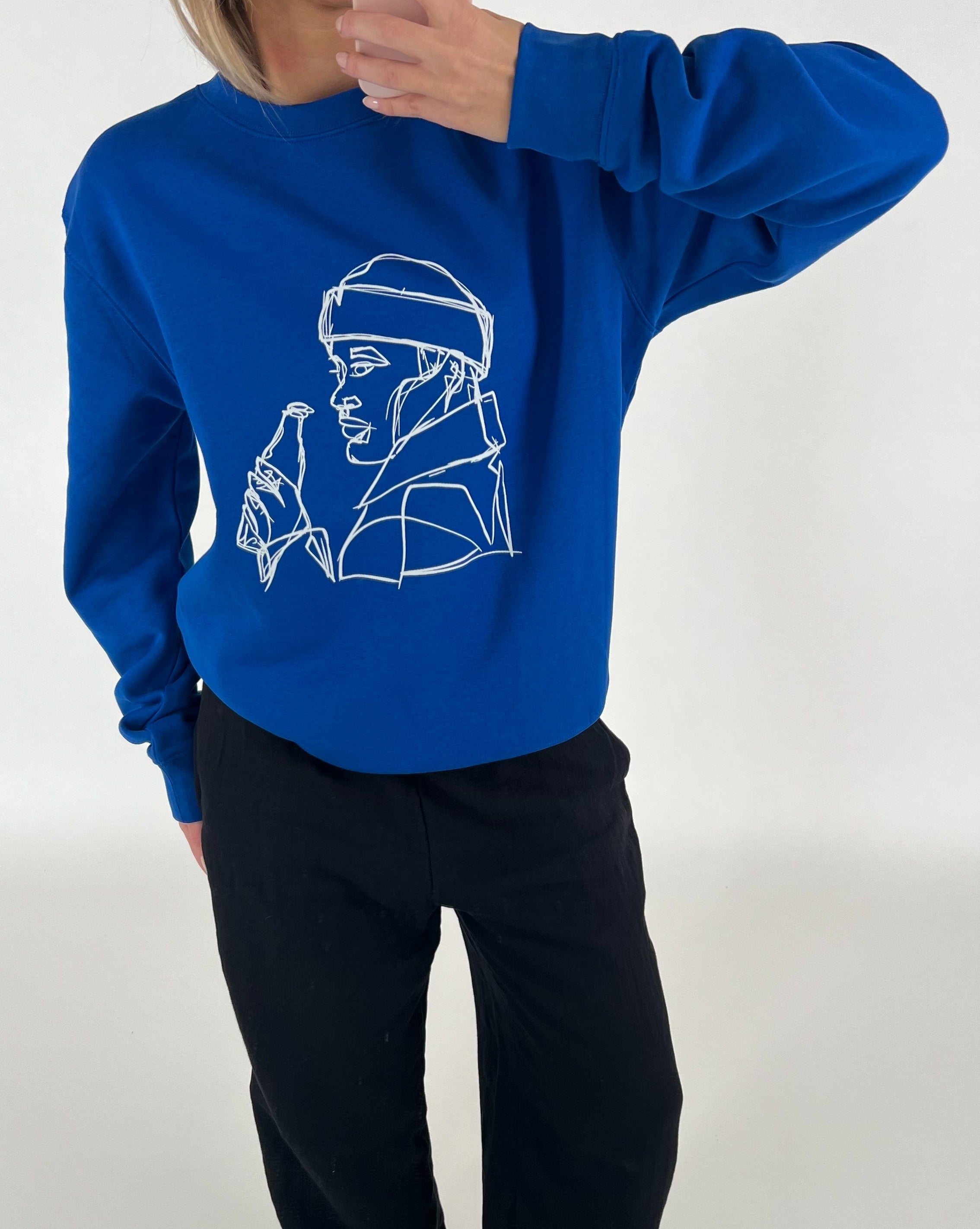 Blå sweatshirt med line art af en person med en flaske. Personen holder en hånd nær ansigtet. Baggrunden er neutral.